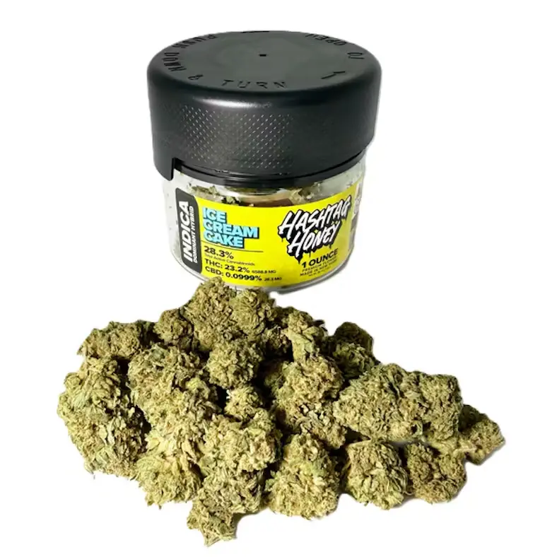 A glass jar with a black lid filled with a bright yellow substance, positioned above a small pile of light brown, honey-like crumbs on a plain white background.