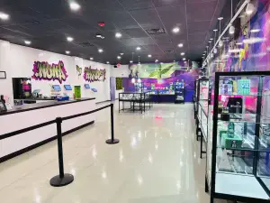 Wide view of Nuna Harvest dispensary interior with display cases and graffiti-style wall art