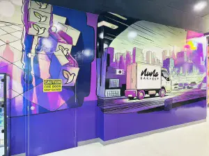 Colorful Nuna Harvest mural featuring delivery truck and city skyline