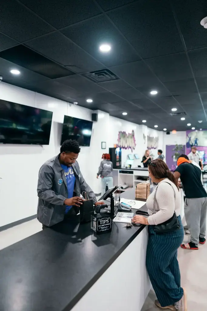 Budtender assisting customer at Nuna Harvest checkout counter
