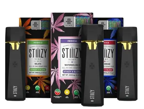 A collection of black STIIIZY vape pods and disposable pens arranged in front of their colorful retail packaging.